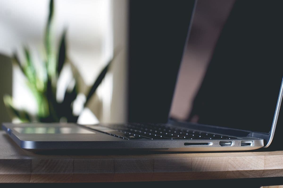 Open Apple MacBook Pro laptop on a wooden desk in soft light